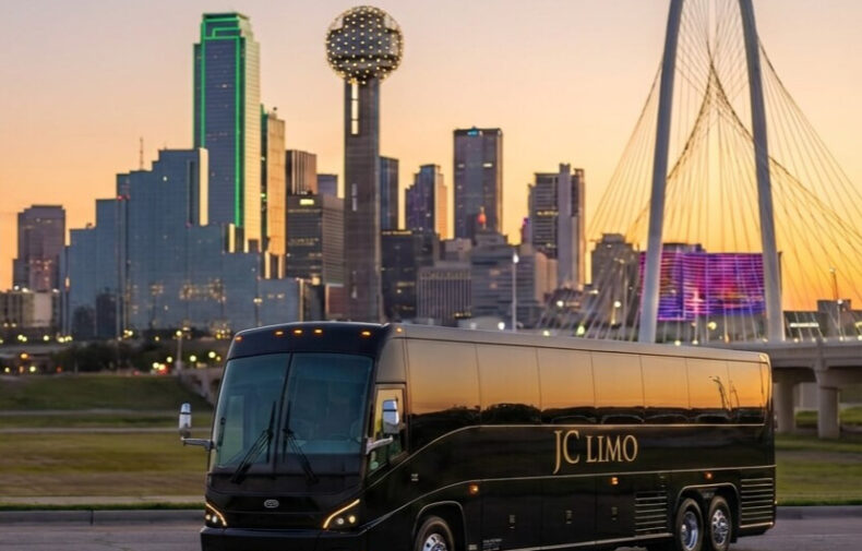 Black JC Limo 56-passenger motor coach parked in front of the Dallas skyline at sunset near Margaret Hunt Hill Bridge, luxury charter bus service in DFW.